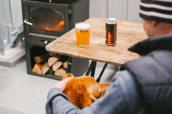 having a beer by the woodburner with the dog, at pipeline brewing co in cornwall